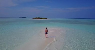 Deniz kıyısında yürüyen genç adam ve kadın. Tropik bir tatil köyünde dinlenen güzel bir çift.    