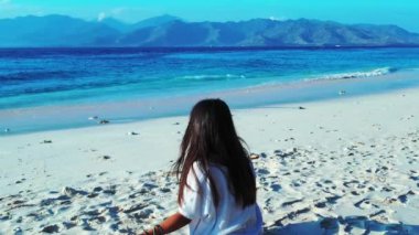 Kız kumsalda oturuyor ve yoga yapıyor.