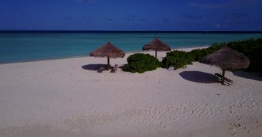 Sabah kumsalında hasır şemsiyeler. Güney Asya, Maldivler 'de yaz deniz manzarası.