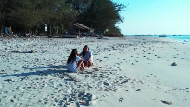 女孩们白天坐在沙滩上 — 图库视频影像