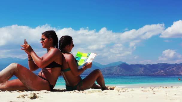 Дві Дівчини Гарно Проводять Час Розмовляють Читають Брошуру Піщаному Пляжі — стокове відео