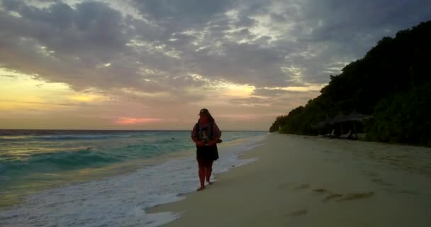 Silhouette Einer Frau Die Bei Sonnenuntergang Mit Rucksack Strand Spaziert — Stockvideo