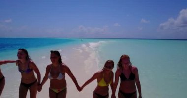 Bikinili kızların el ele tutuşup deniz tırpanı üzerinde yürüdüklerini videoya çek.