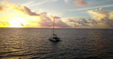 Gün batımında denizde yelken açan küçük bir tekne. Tayland manzarası.