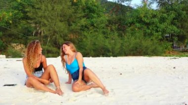 Tropik adanın kumlu sahillerinde dinlenen kızlar, yaz tatili konsept görüntüleri 
