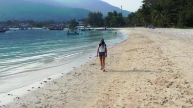 Sırt çantalı kadın turist tropik ada sahillerinde yürüyor, yaz tatili konsepti  
