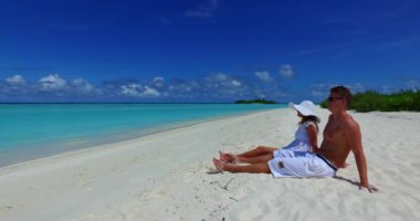 Genç bir adam ve kadın deniz kıyısında güneşleniyorlardı. Tropik bir tatil köyünde dinlenen güzel bir çift.   