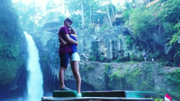 美丽的女孩和男朋友在瀑布边玩得很开心 旅行的概念镜头 — 图库视频影像