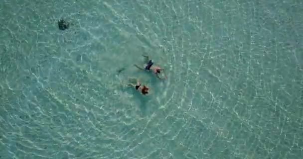 年轻男女在海水中游泳 美丽的夫妻在热带度假胜地休息 — 图库视频影像