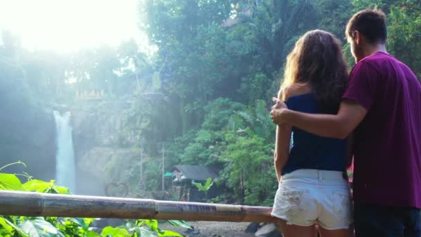 美しいです若いです女性とともに彼女のボーイフレンド立って近く滝 旅行コンセプト — ストック動画