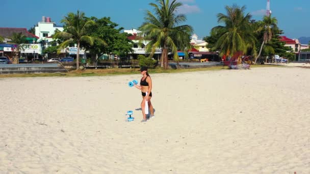 Brunetka Kobieta Czarnym Stroju Kąpielowym Robi Ćwiczenia Hantlami Plaży Materiał — Wideo stockowe