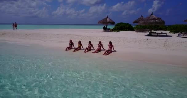 Bikinili Bronz Kızları Beyaz Kumlu Sahilde Sırayla Uzanmış Güneşlenirken Videoya — Stok video