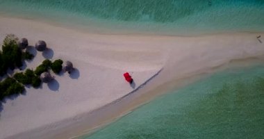 Yumuşak dalgalı deniz kıyısı manzarası tropikal adanın kenarında, plajda dinlenme yerleri olan güneşlikler, Bali, Endonezya.