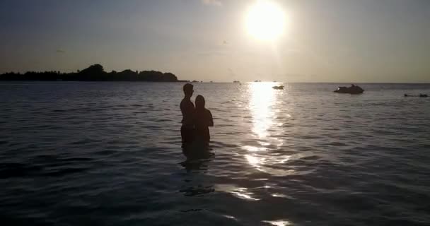 Νεαρό Ζευγάρι Χαλαρώνοντας Στην Παραλία Κατά Ηλιοβασίλεμα Στην Ταϊλάνδη — Αρχείο Βίντεο
