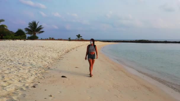 Θέα Ενός Κοριτσιού Μάσκα Περπατώντας Στην Αμμώδη Παραλία — Αρχείο Βίντεο