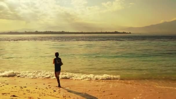 Młody Rybak Wędką Stojący Oceanicznej Plaży Przy Pomarańczowym Zachodzie Słońca — Wideo stockowe