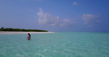 Kumsalda beyaz kumlu bikinili bir kadın, güneşli bir günde turkuaz deniz ve mavi gökyüzü, doğal çevre..