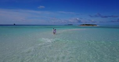 Genç bir adam ve kadın deniz suyunda daireler çiziyor. Tropik bir tatil köyünde dinlenen güzel bir çift. 