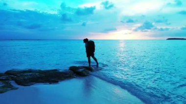 Gün batımında sahilde bir kadın silueti