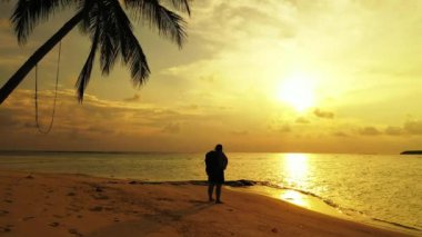 Gün batımında Sahilde Yürüyen Kadın