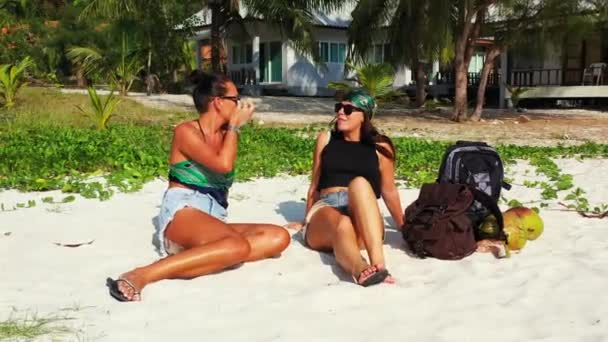 Två Unga Flickvänner Sitter Sandkusten Med Bagage Bredvid Sig Och — Stockvideo