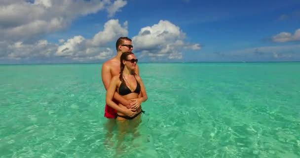 若い男と女性の海の水と抱擁立っている 美しいカップルは熱帯リゾートに休みます — ストック動画