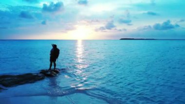 Gün batımında sahilde bir kadın silueti