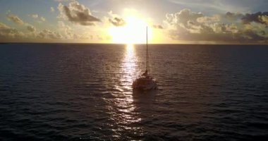 Günbatımında, Tayland 'da, denizde küçük dalgalarda sallanan yalnız bir tekne..