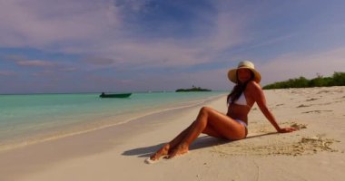 Bronzlaşmış genç bir kadın yaz gününde mavi denizde dinleniyor. Bora Bora adasında egzotik tatil.