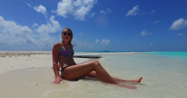 在马尔代夫 穿着比基尼的漂亮女人在海里舒缓着舒缓的腿 背景是冲浪板 — 图库视频影像