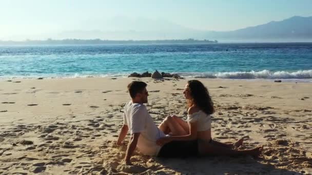 トロピカルビーチに座っているロマンチックなカップルは — ストック動画