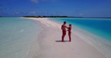 Deniz suyunda duran genç adam ve kadın. Tropik bir tatil köyünde dinlenen güzel bir çift.    