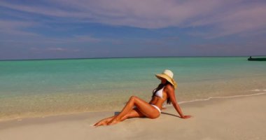 Bronzlaşmış genç bir kadın yaz gününde mavi denizde dinleniyor. Bora Bora adasında egzotik tatil.