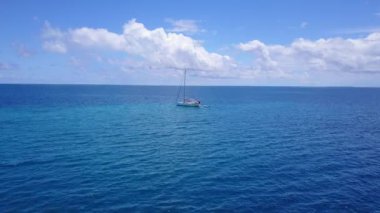 Mavi denizde hareket eden bir yat. Bahamalar Doğası, Karayipler.