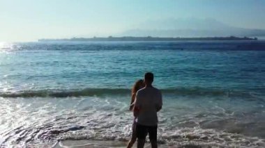 Güzel genç çift tatilin tadını çıkarıyor ve okyanusun yakınındaki güzel tropikal sahilde dinleniyor. 