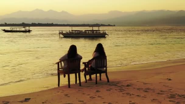 砂浜に座っている二人の女の子 — ストック動画