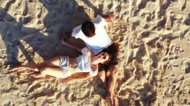 Bir adamın sevgilisiyle kumlu ada sahillerinde, romantizm ve yaz seyahati konseptinde rahatlarken çekilmiş bir video. 