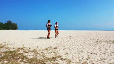 Sahilde egzersiz yapan çekici atletik kadınlar. 