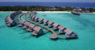 Kıyı şeridi boyunca bungalovları olan bir ada. Bora Bora 'da yaz tatili, Fransız Polinezyası.
