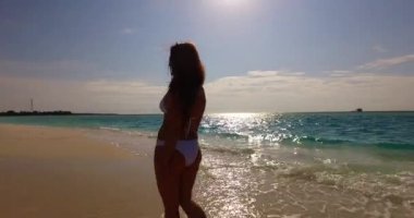 Bronzlaşmış genç bir kadın yaz gününde mavi denizde dinleniyor. Bora Bora adasında egzotik tatil.