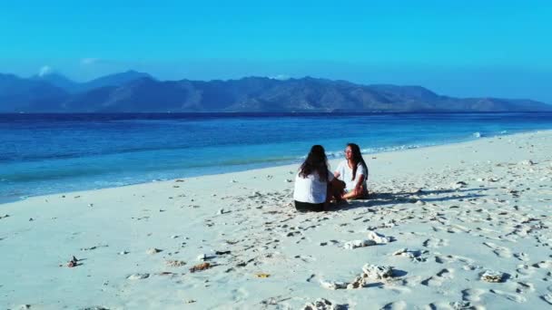 Κορίτσια Που Κάθονται Στην Αμμώδη Παραλία Την Ημέρα — Αρχείο Βίντεο