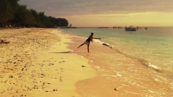 Indonesisk Fiskare Med Sitt Långa Spö Stående Havet Vid Den — Stockvideo