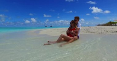 Genç bir adam ve kadın deniz kıyısında güneşleniyorlardı. Tropik bir tatil köyünde dinlenen güzel bir çift.    