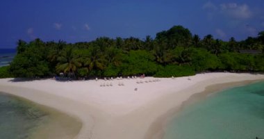 Kumsalda şezlonglar ve yeşil ağaçlar. Barbados, Karayiplere Seyahat.