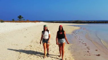 Sahilde yürüyen kadınların yüksek açılı görüntüleri. 