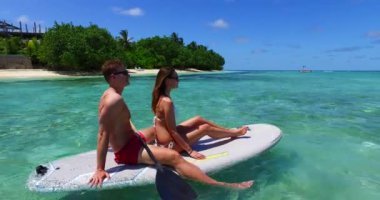 Sahilde sörf tahtasında sörf yapan eğlenceli bir çift Büyük Ada, Hawaii 'de birlikte sörf yapıyorlar.