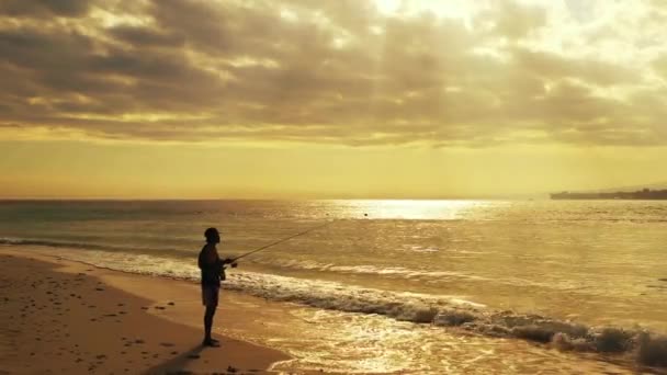 Pescatore Pesca Con Una Canna Sulla Spiaggia Dell Oceano Tramonto — Video Stock