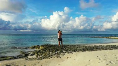 Sahilde fotoğraf çeken bir kadın. 