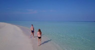 Genç adam ve kadın deniz kıyısında valeybol oynuyorlar. Tropik bir tatil köyünde dinlenen güzel bir çift.    