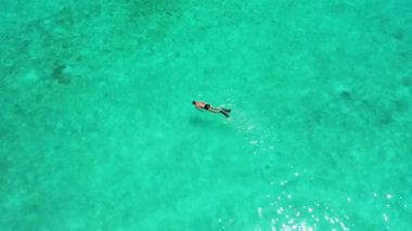 Mercan resifinin üzerinde egzotik açık denizde şnorkelle yüzen genç adam, Bali.